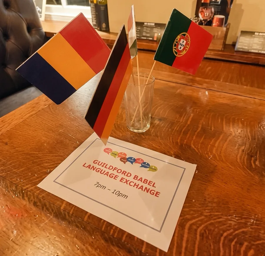 Table flags and a Guildford Babel Language Exchange sign on a pub table
